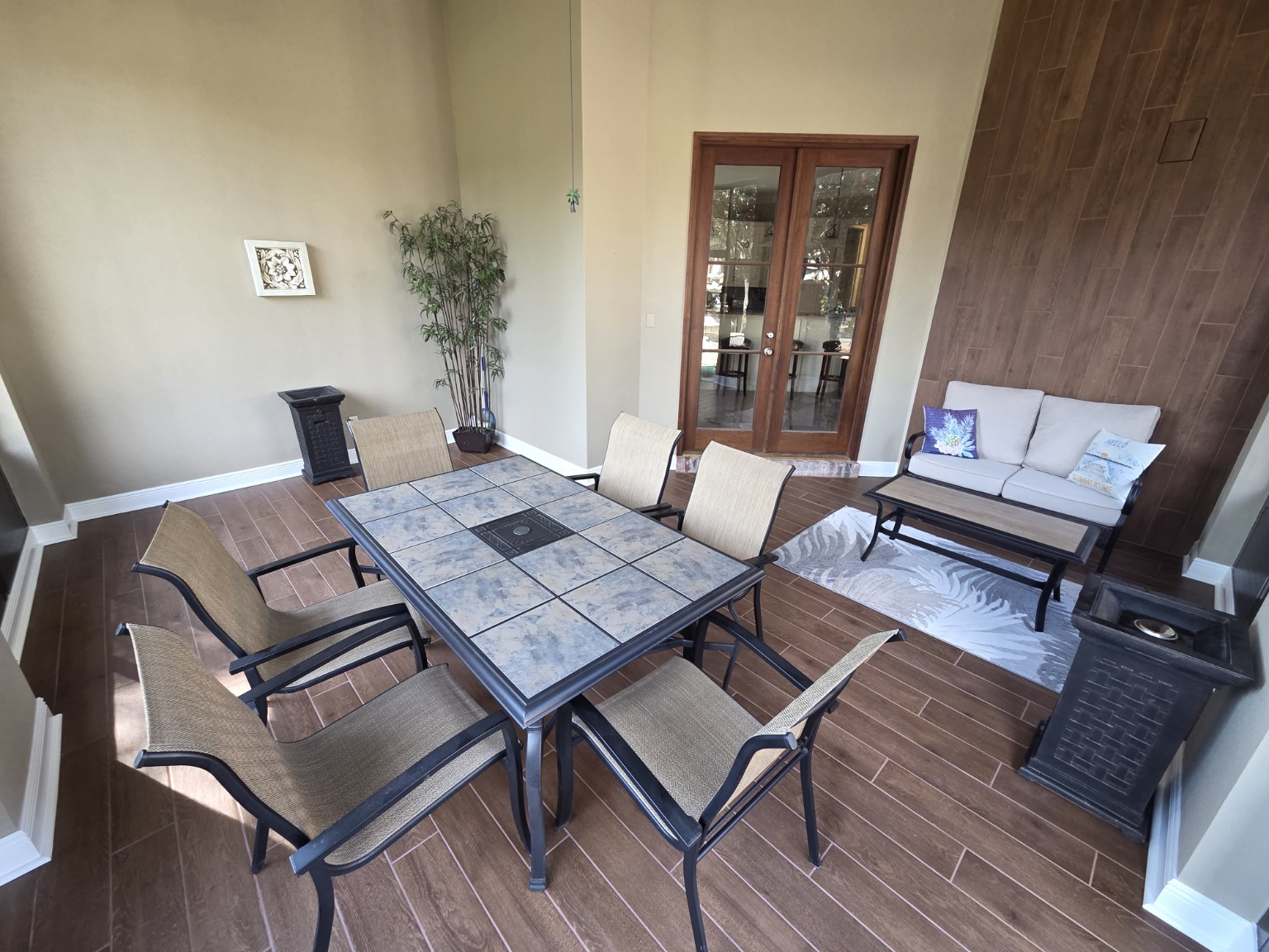 Finished Northshore patio with wood-look tile floor, vertical tile accent wall, and outdoor furniture